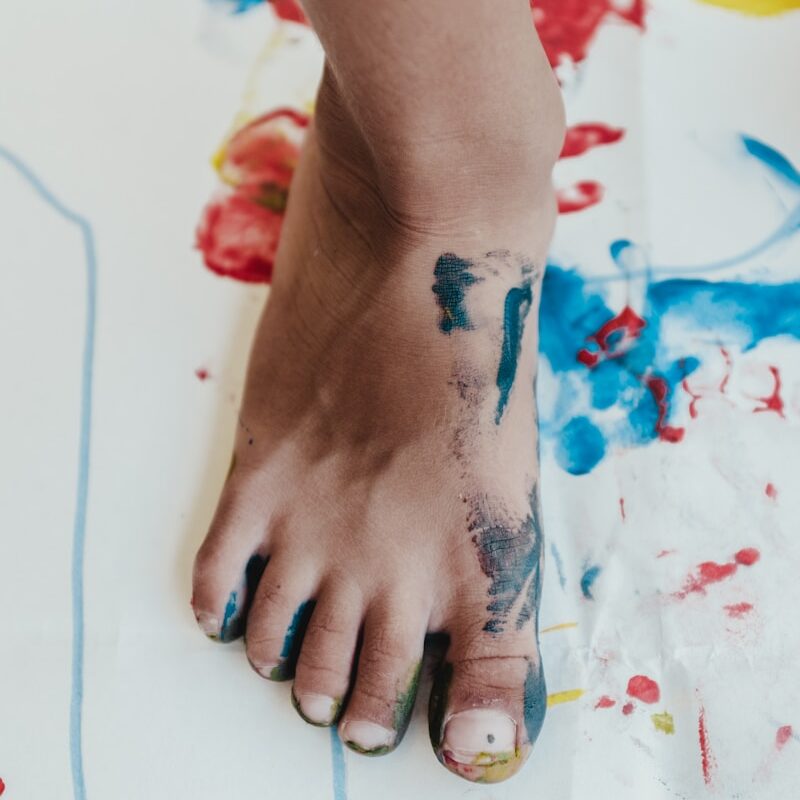 person his right foot painting on white paper